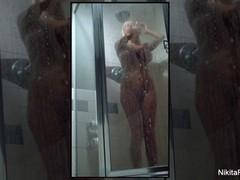 Busty blonde Nikita von James splashing in the shower.